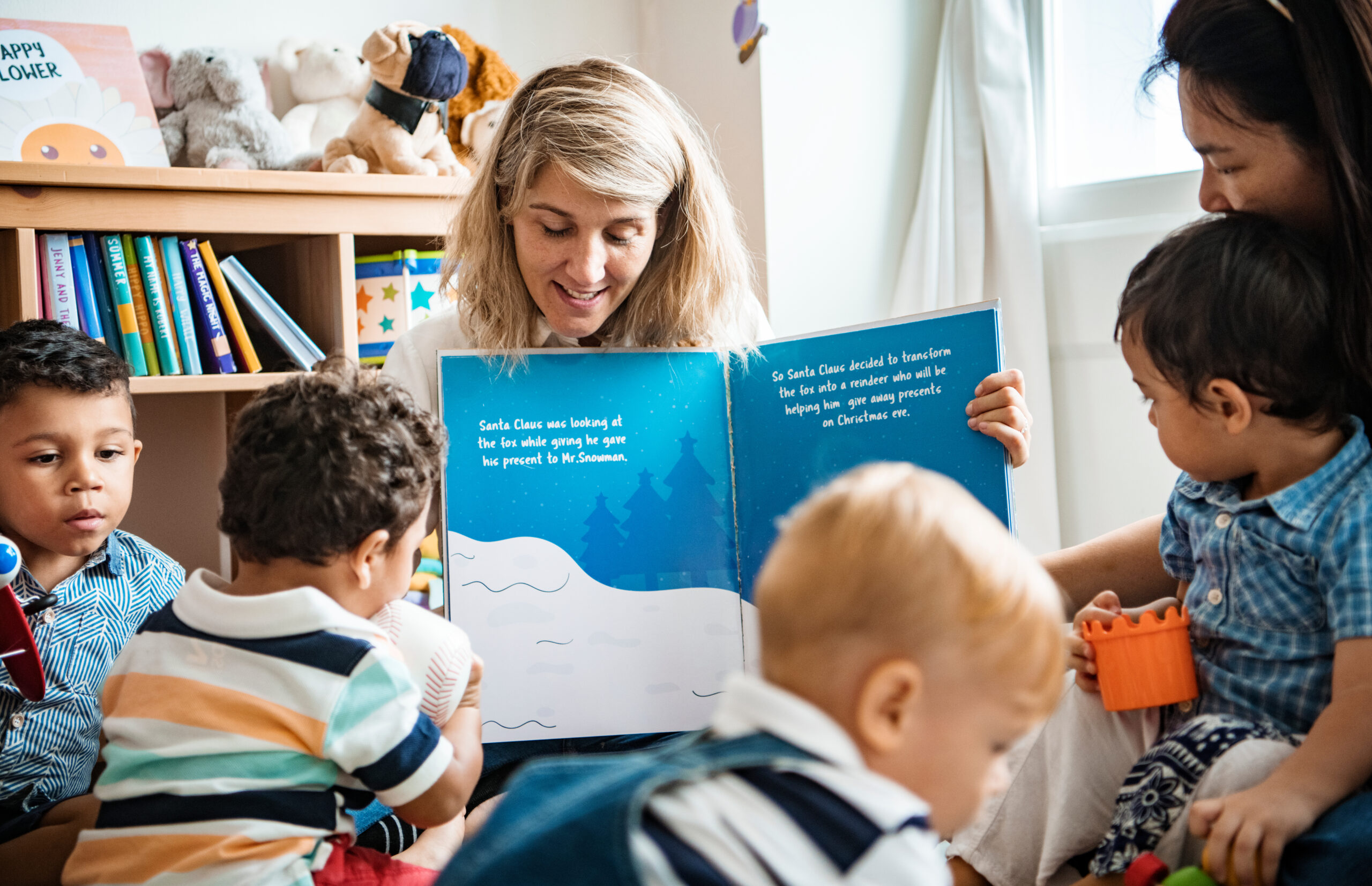 Teachers read a book to children