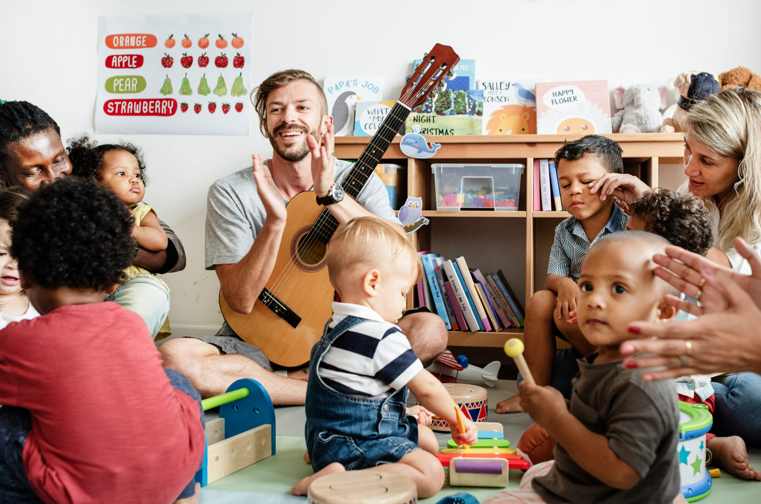 Nursery children playing with musical instruments in the classro Children and adults play with toys and musical instruments in a classroom