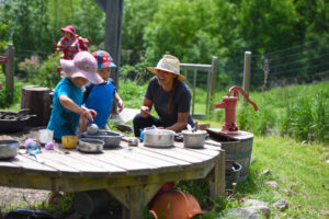 Teacher interacts with children in outdoor learning