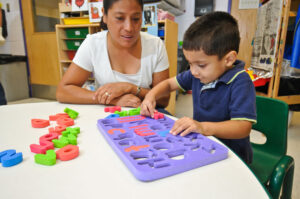 Child and teacher play an alphabet game together