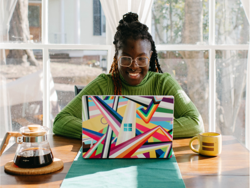 Adult smiles while looking at a laptop in a home