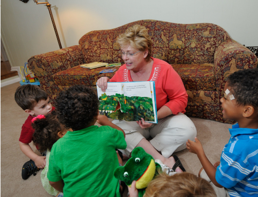 Teacher reading a book to children